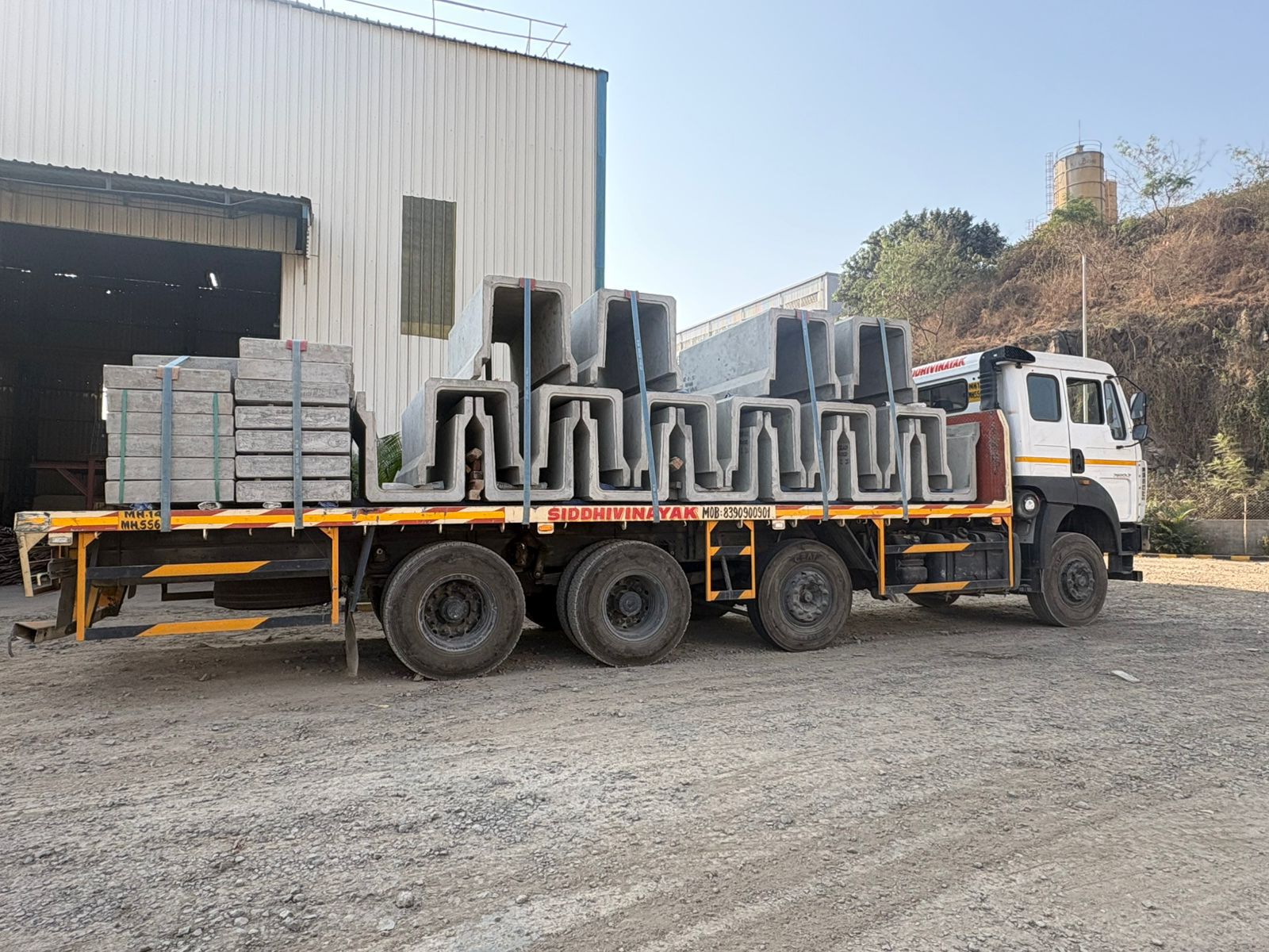 Flatbed truck loaded with precast concrete sections for industrial transport