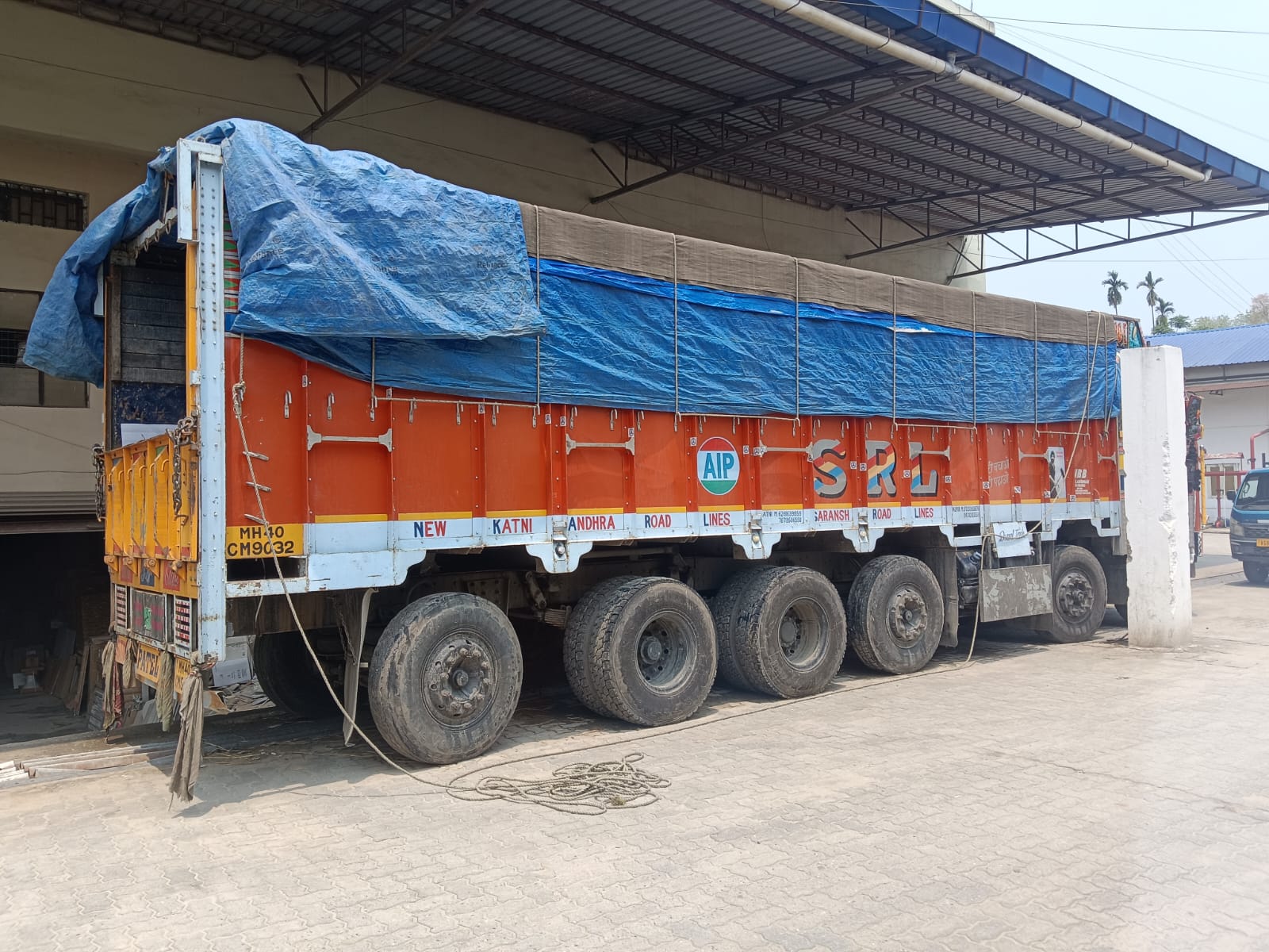 Tarpaulin-covered full load open truck ready for commercial goods transport