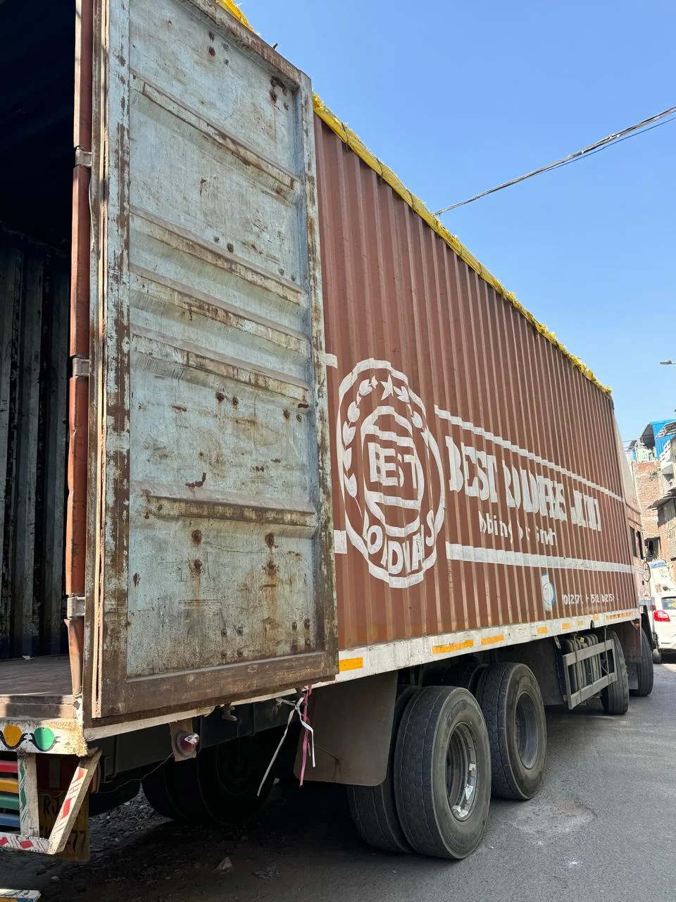 32 Ft Truck Booking in Pune | SXL & MXL 1 Large brown closed-body container truck parked beside a loading area