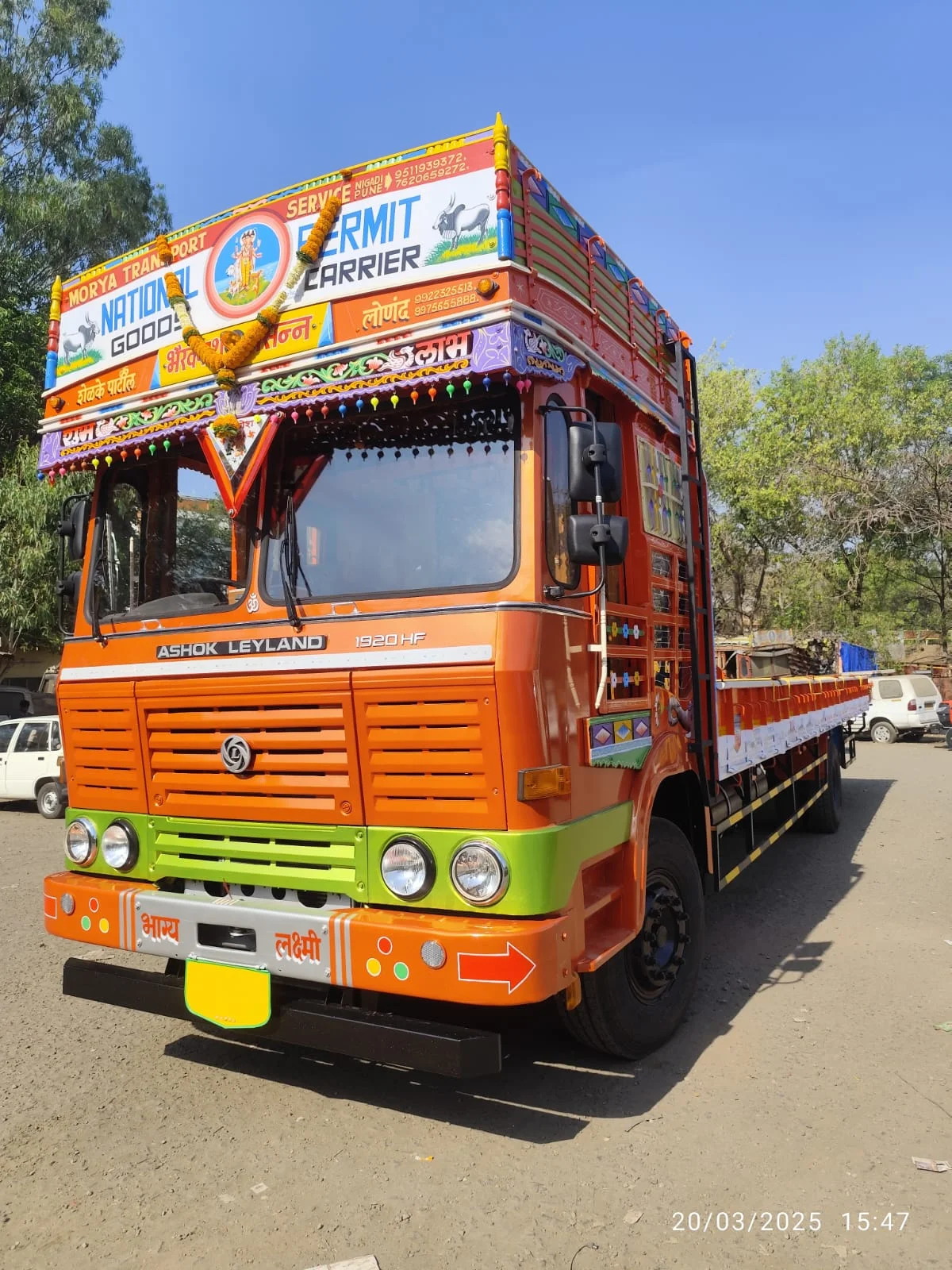 Orange open-body commercial goods truck parked outdoors